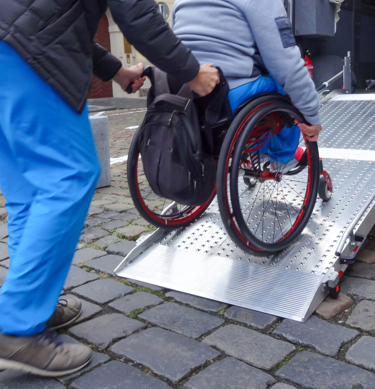 An image of a wheelchair user entering the back of a patient transport vehicle