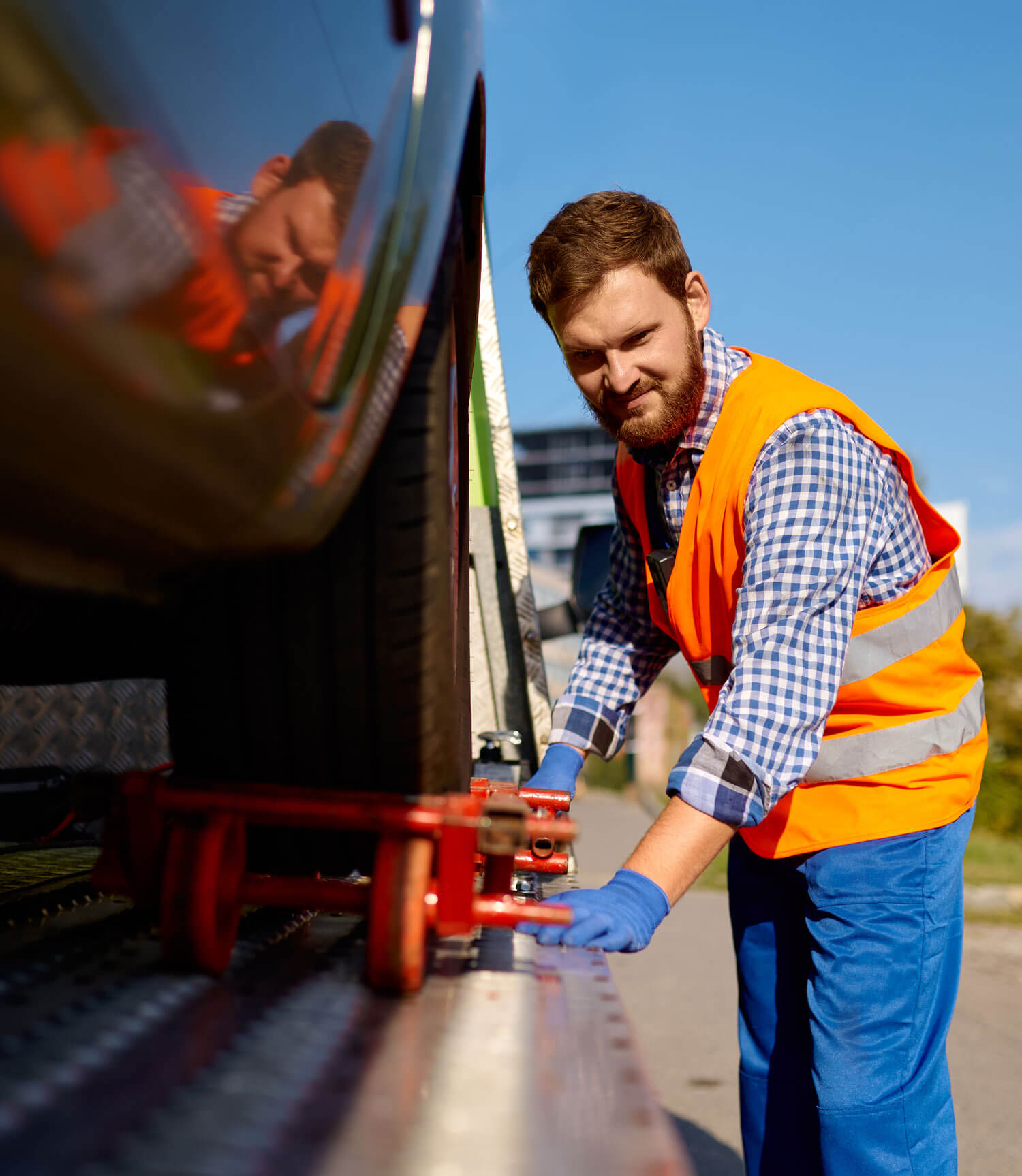 An image showing a person winching a vehicle onto a tow truck